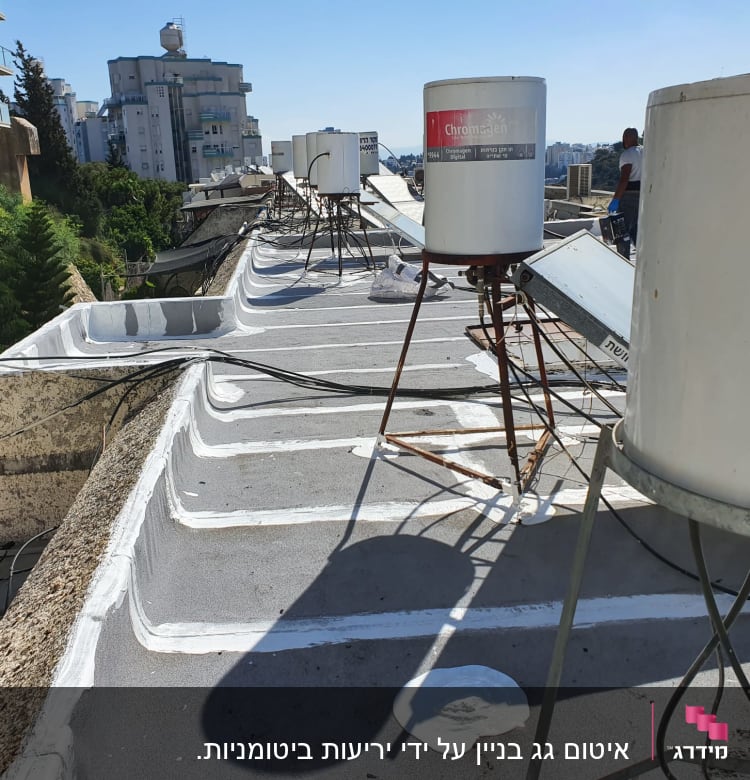 איטום גג עם חומר לבן סביב דודי שמש